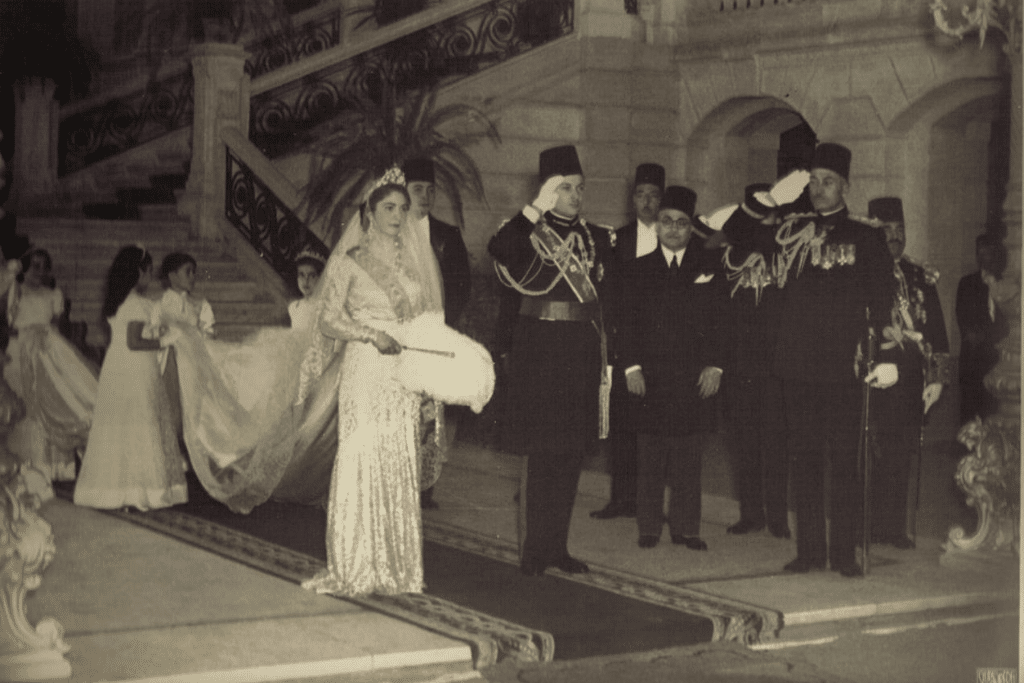 Queen Farida of Egypt in her wedding dress standing next to King Farouk