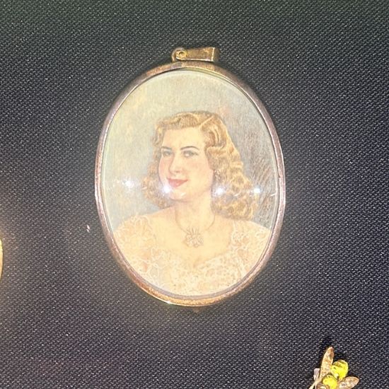 Queen Narriman's silver pendant with an enamelled picture of her engagement, from the NMEC.